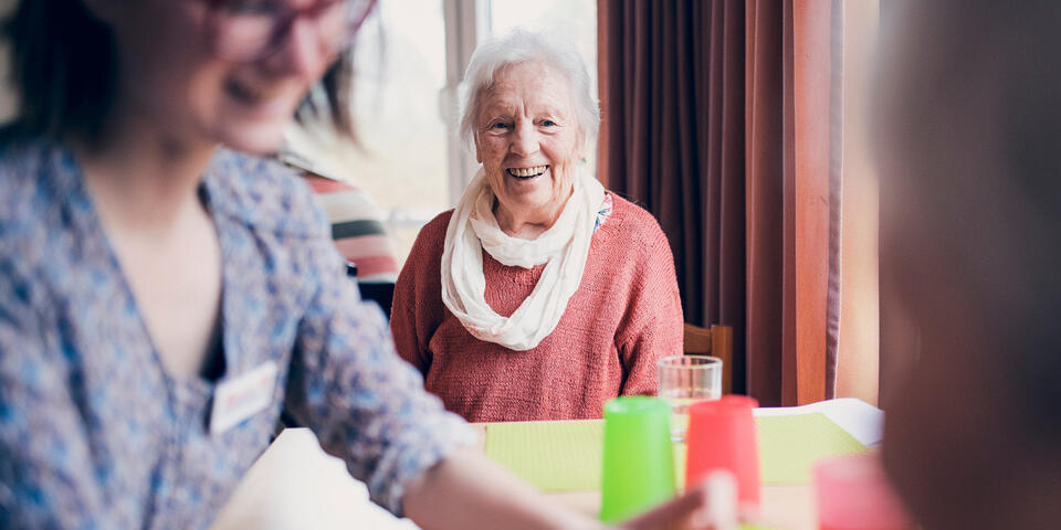 Eine Seniorin und eine Mitarbeiterin bei einem Spiel