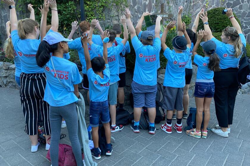 Die Kinder der Ferienbetreuung strecken die Hände in die Luft