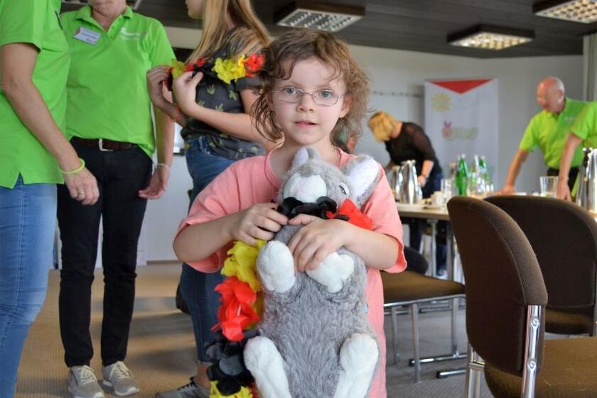 Ein Kind, das vom Hospizdienst begleitet wird, hält bei einem Treffen einen Teddy im Arm.