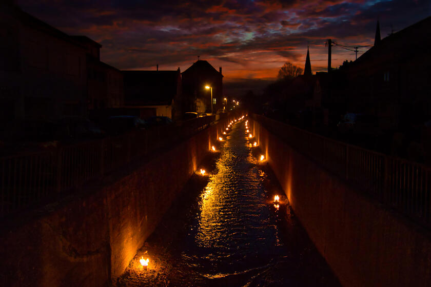 Das Foto zeigt den mit Fackeln beleuchteten Orbach bei Nacht.