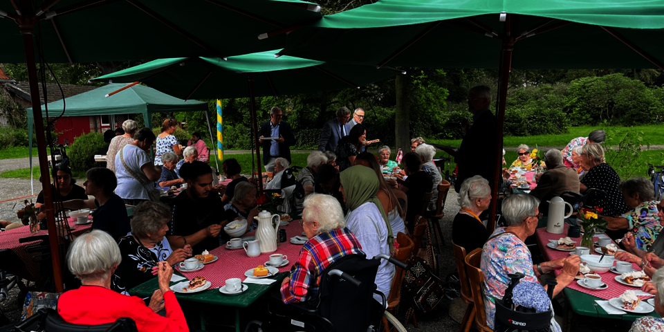 mehrere Kaffeetische unter großen grünen Schirmen