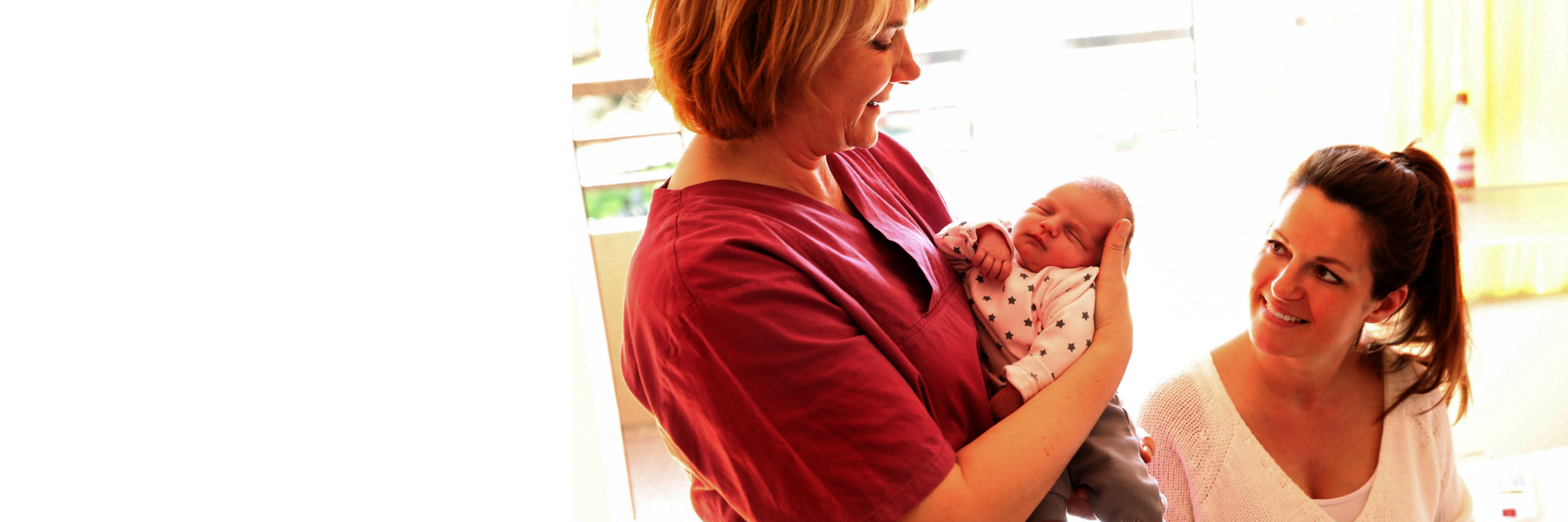 Hebamme betreut Mutter und Kind auf der Geburtsstation in Bonn