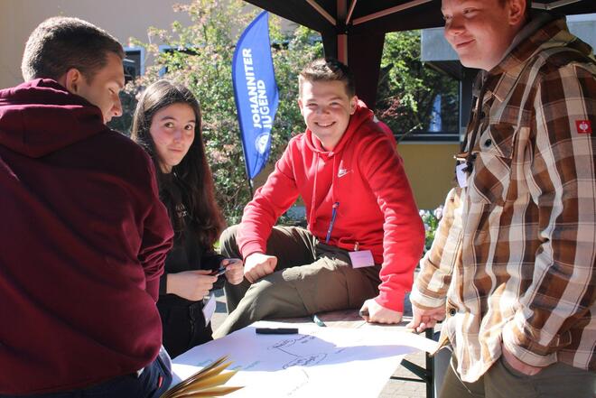 Gruppe Jugendlicher, die an einbem Flipchart arbeiten.