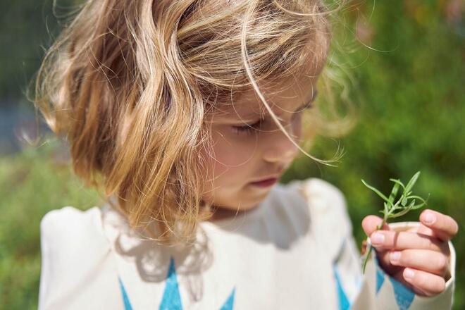 Ein Mädchen schaut sich eine Blumen an