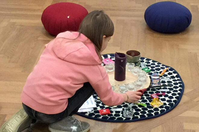 Teilnehmerin einer Lacrima-Kindergruppe in Oberfranken beim Anzünden einer Kerze für das Kerzenritual