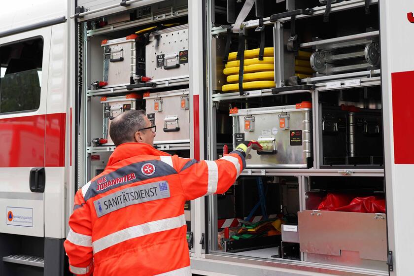 Ehrenamtlicher holt Material aus dem Einsatzfahrzeug zum Aufbau einer Sanitätsstation