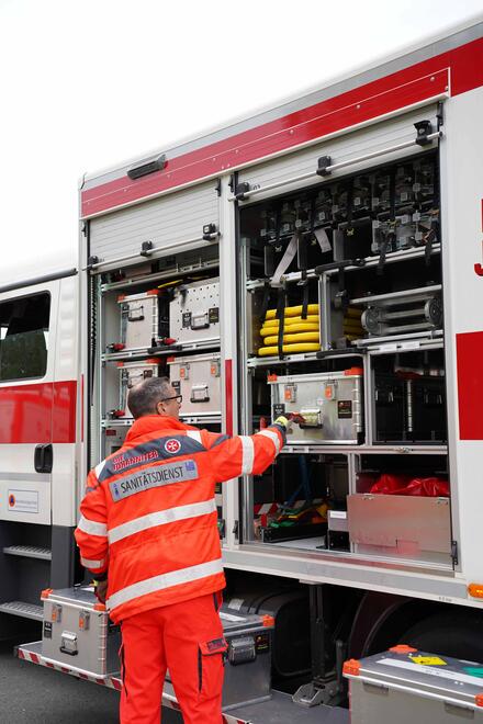 Ehrenamtlicher holt Material aus dem Einsatzfahrzeug zum Aufbau einer Sanitätsstation