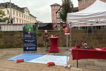 Frau am dekorierten Sozialmarktstand der Johanniter vor der Elisabethkirche in Marburg