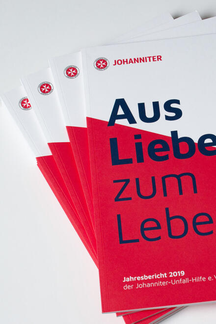 Mehrere Flyer mit der Aufschrift "Aus Liebe zum Leben" liegen übereinander.