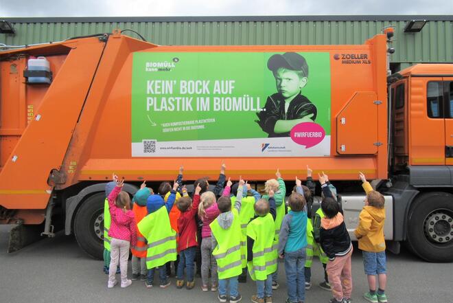 Kinder vor einem Müllwagen