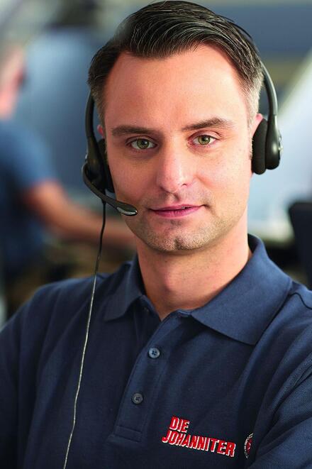 Johanniter-Mitarbeiter telefoniert in der Hausnotruf-Zentrale
