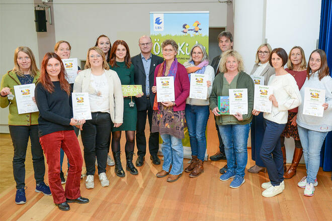 Eine Gruppe an Leuten schaut in die Kamera und halten ein Zertifikat in der Hand.