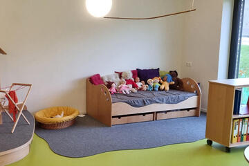 Gemütliches Sofa mit Puppen und Kuscheltieren zum Spielen.