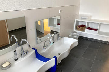 Sehr tiefhängende Waschbecken und kleine Spiegel. 