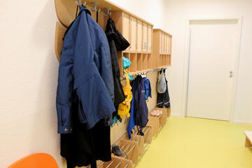 Große und kleine Jacken in allen Farben und kleine Schuhe sind zu sehen.