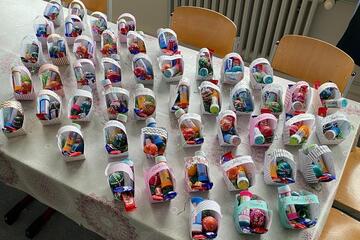 Auf einem Tisch stehen zahlreiche selbstgebastelte Körbchen mit Ostereiern.