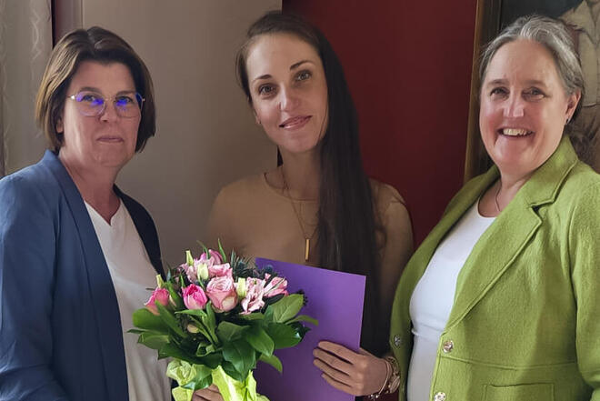 Zwei Mitarbeiterinnen der Johanniter sowie eine Auszubildende lächeln in die Kamera.