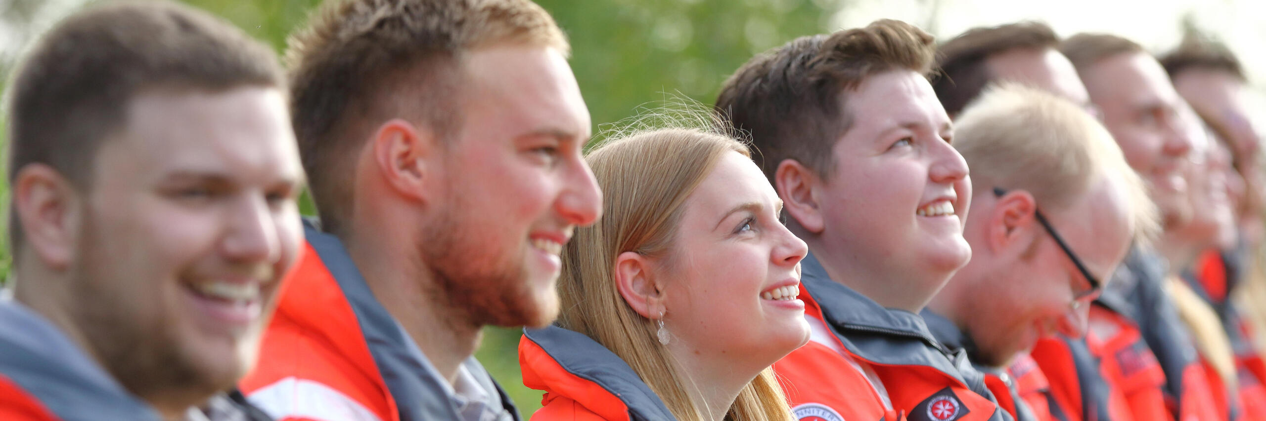 Gruppe von verschiedenen Menschen in einer Reihe. Sie lachen und freuen sich.