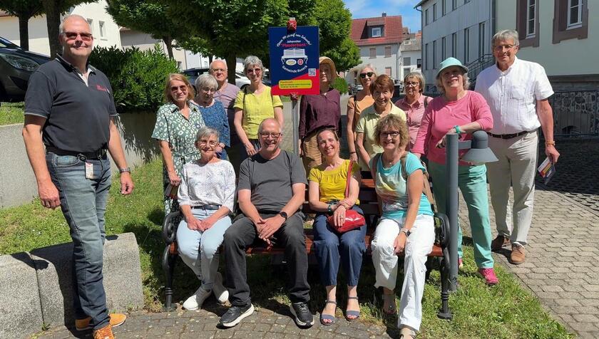 Mehrere Personen auf der neuen Johanniter-Plauderbank in Alten-Buseck