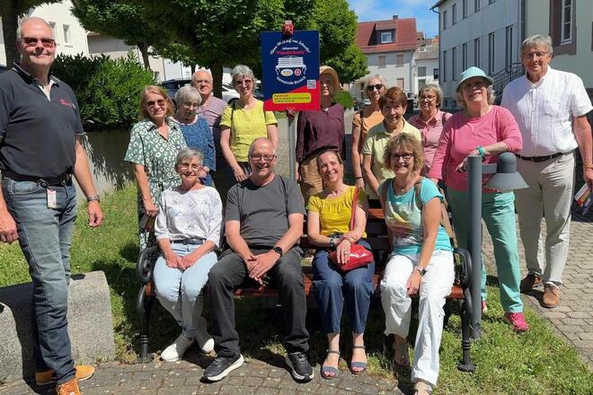 Mehrere Personen auf der neuen Johanniter-Plauderbank in Alten-Buseck