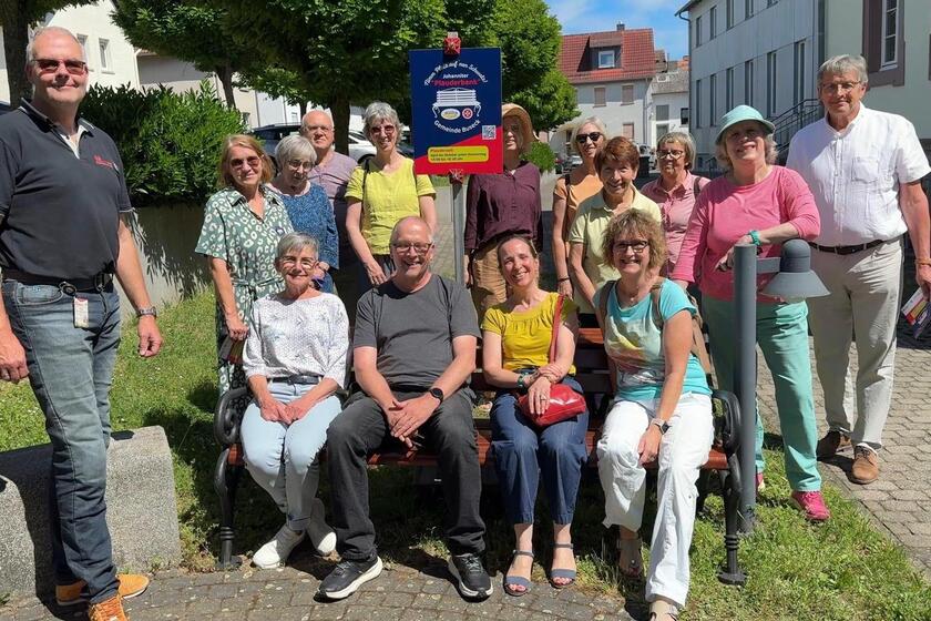 Mehrere Personen auf der neuen Johanniter-Plauderbank in Alten-Buseck