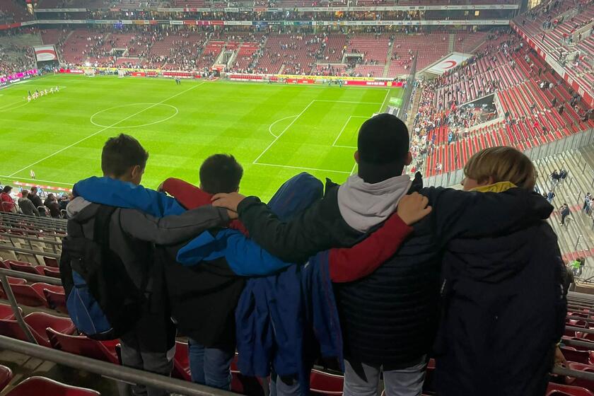 Kinder besuchen schauen auf das Spielfeld im Stadion