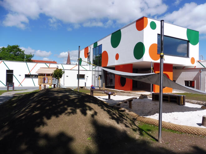 Ein Gebäude mit Spielgeräten für Kinder im Vordergrund