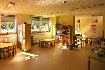 Blick in das Kinderrestaurant mit Tischen, Stühlen und Schränken.