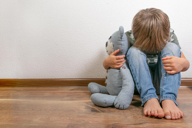 Trauerndes Kind mit Kuscheltier