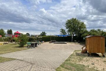 Außenberiech der Kita Pustewind, mit einem Bauwagen, Sandlasten und Spielplatz