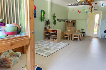 Ein Raum mit verschiedenen Schränken und Tischen mit Spielsachen.