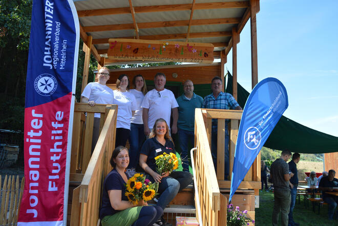 Gruppenbild: Das Team der Waldkita steht vor dem Eingang vom Bauwagen