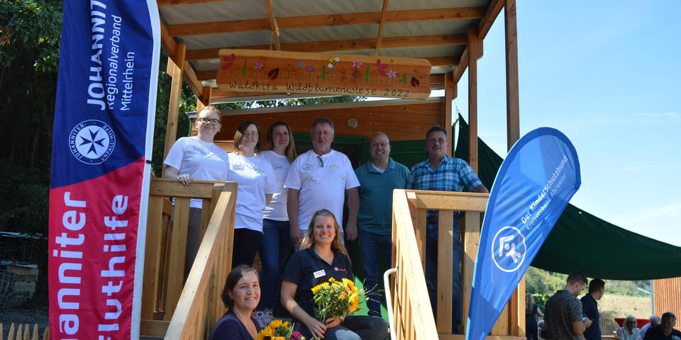 Gruppenbild: Das Team der Waldkita steht vor dem Eingang vom Bauwagen