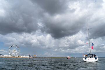 Segelboot der Johanniter fährt am Leuchtfeuer von Travemünde vorbei.