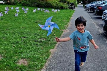 Ein Junge läuft mit seinem Windrad