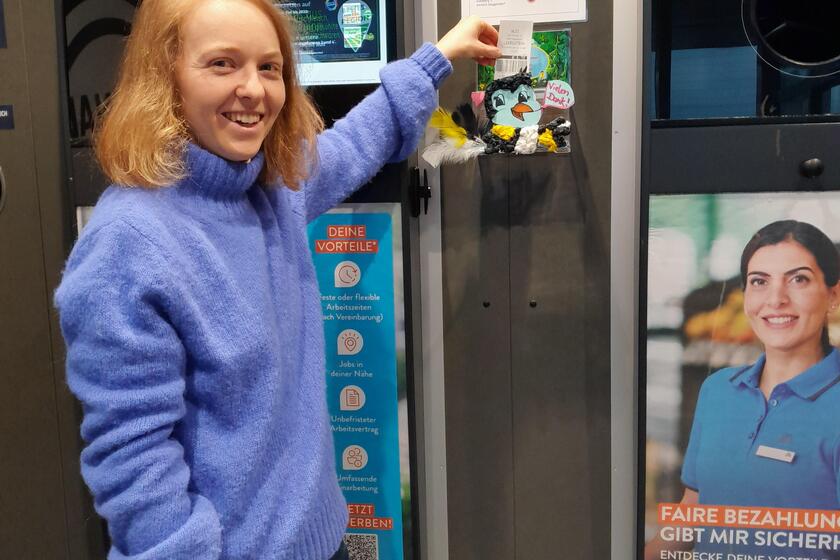 Frau wirft Bon in Spendenbox