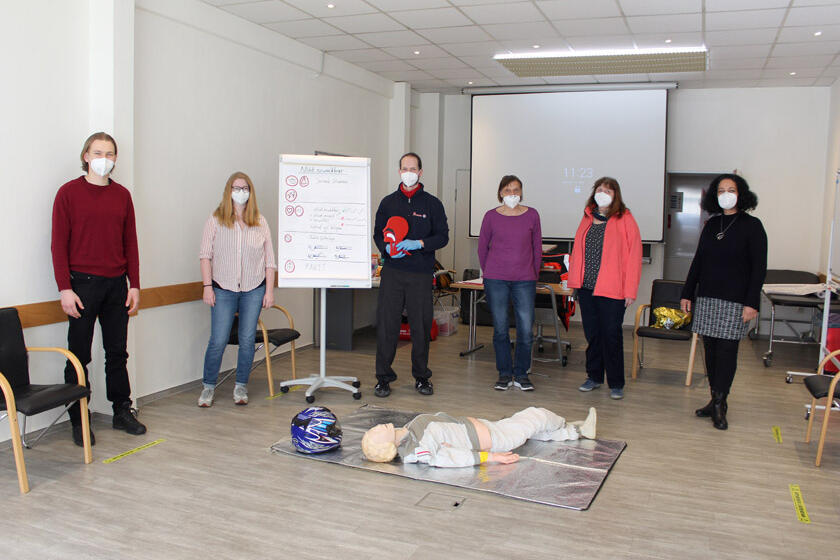 Gruppenfoto der Mitarbeitenden gemeinsam mit Erste-Hilfe-Trainer Sebatsian Zuber.