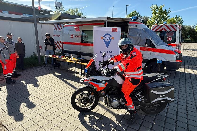 Einsatzmotorrad steht vor einem Einsatzwagen.