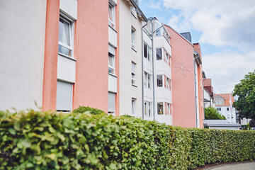 Sicht vom Weg auf die helle mit rot abgesetzter Hausfront vom Johanniter-Stift Oeneking in Lüdenscheid.