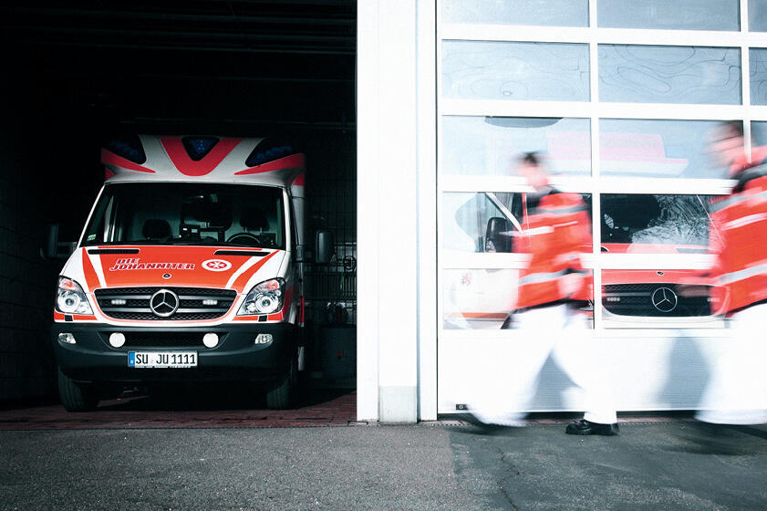 Ein Rettungswagen und Mitarbeitende des Rettungsdienstes der Johanniter-Unfall-Hilfe.