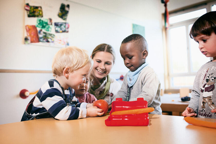 Erzieherin mit drei Kindern
