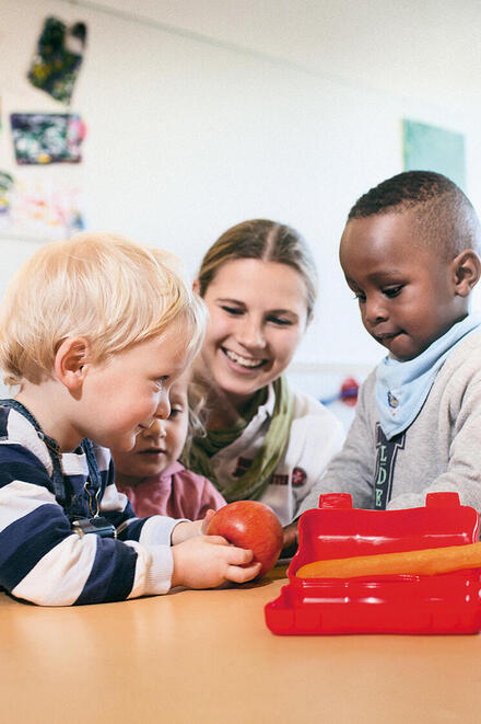 Erzieherin mit drei Kindern