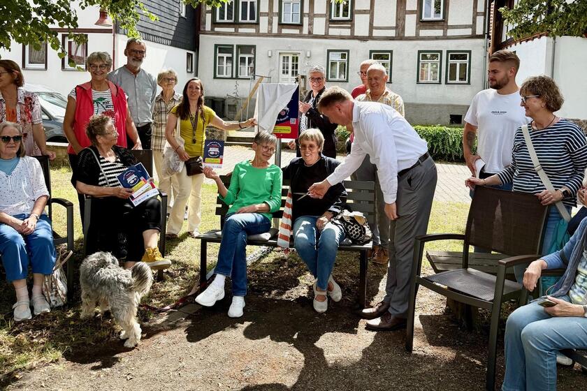 Gruppenfoto Menschen um neue Plauderbank herum