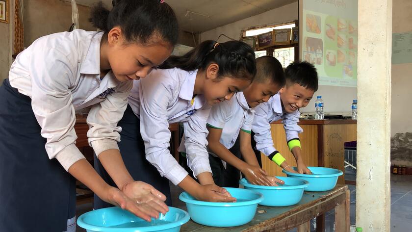 Vier Kinder waschen sich die Hände