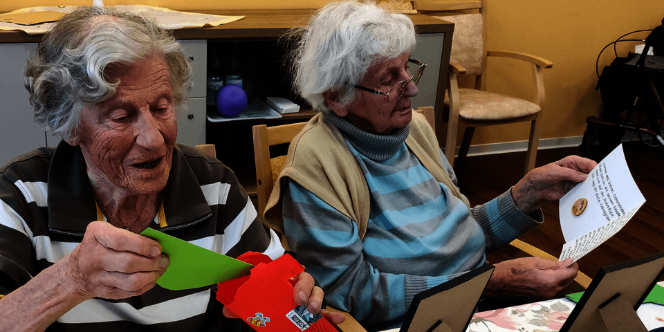 zwei ältere Damen lesen Ostergrüße