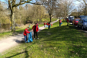 Bewohnende und Mitarbeitende der Landesunterkunft Kiel sammeln Müll in der Wik ein.