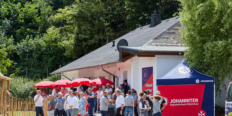 Seitenansicht des Treffpunkt "vor Müllert" mit roten Sonnenschirmen