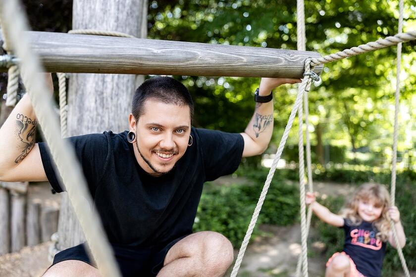 Ein Erzieher spielt mit einem Kind auf dem Spielplatz