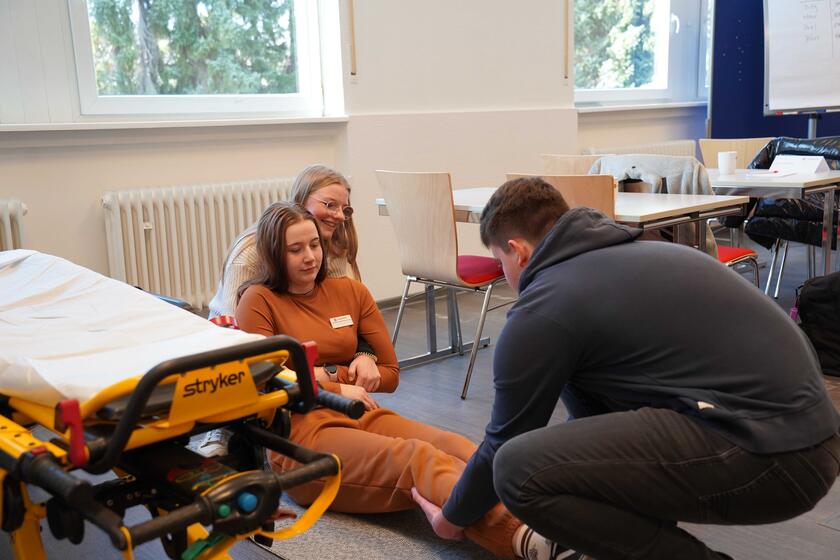 Übung beim Assessment-Center des Rettungsdienstes, hochhelfen einer am Boden liegender Person