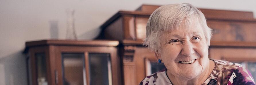 Eine Bewohnerin lächelt freundlich